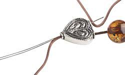 Cord and a needle threaded through a metal bead